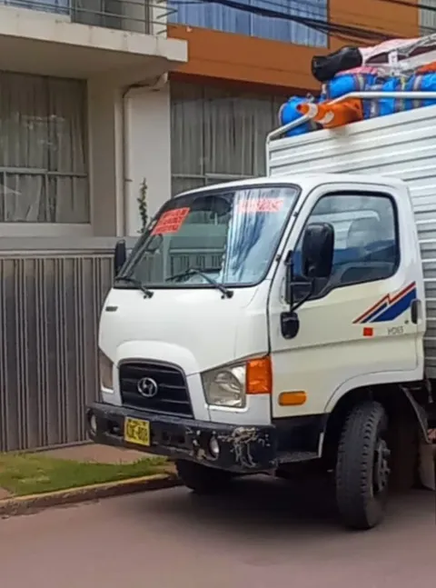 Camión de Mudaltoke cargado con una mudanza frente a un edificio de departamentos en Cusco