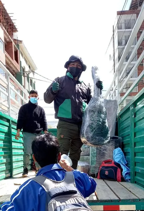 Cargador entregando un mueble embalado desde la plataforma del camión